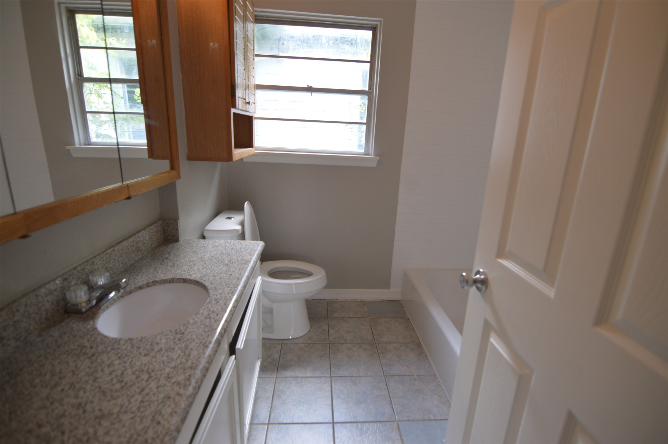 1403 Elton Street Houston, TX 77034 - Photo 14 of 21 a bathroom with a granite countertop sink toilet and a tub