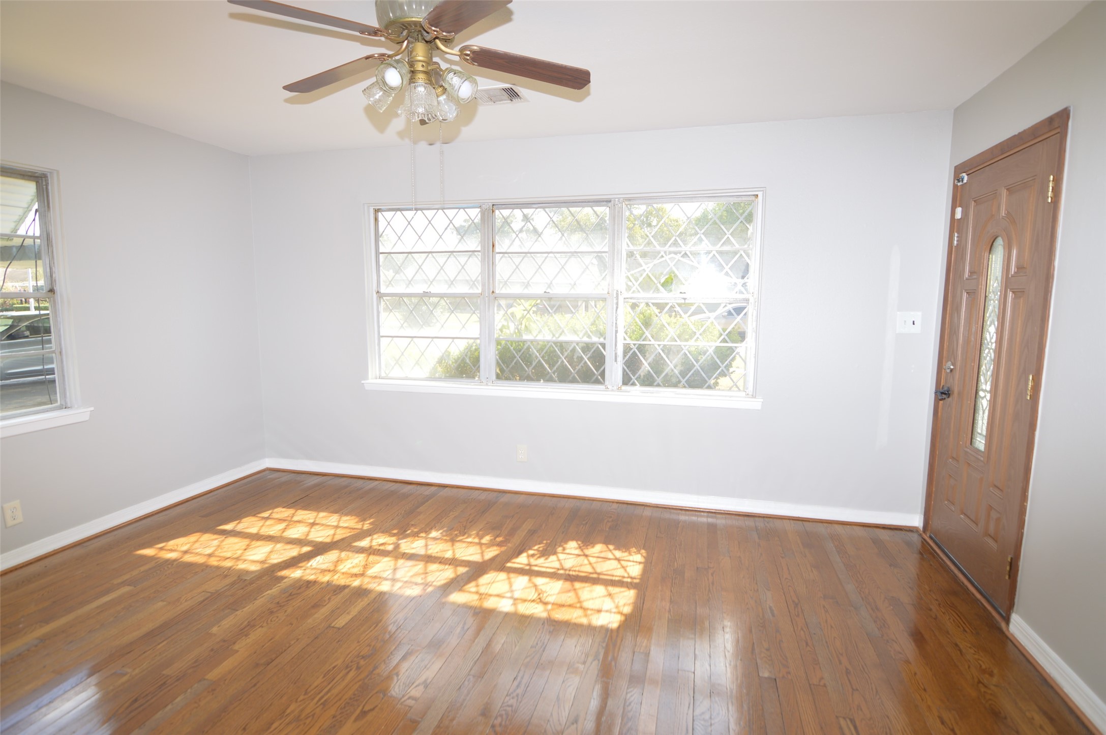 1403 Elton Street Houston, TX 77034 - Photo 3 of 21 a view of an empty room with wooden floor and a window