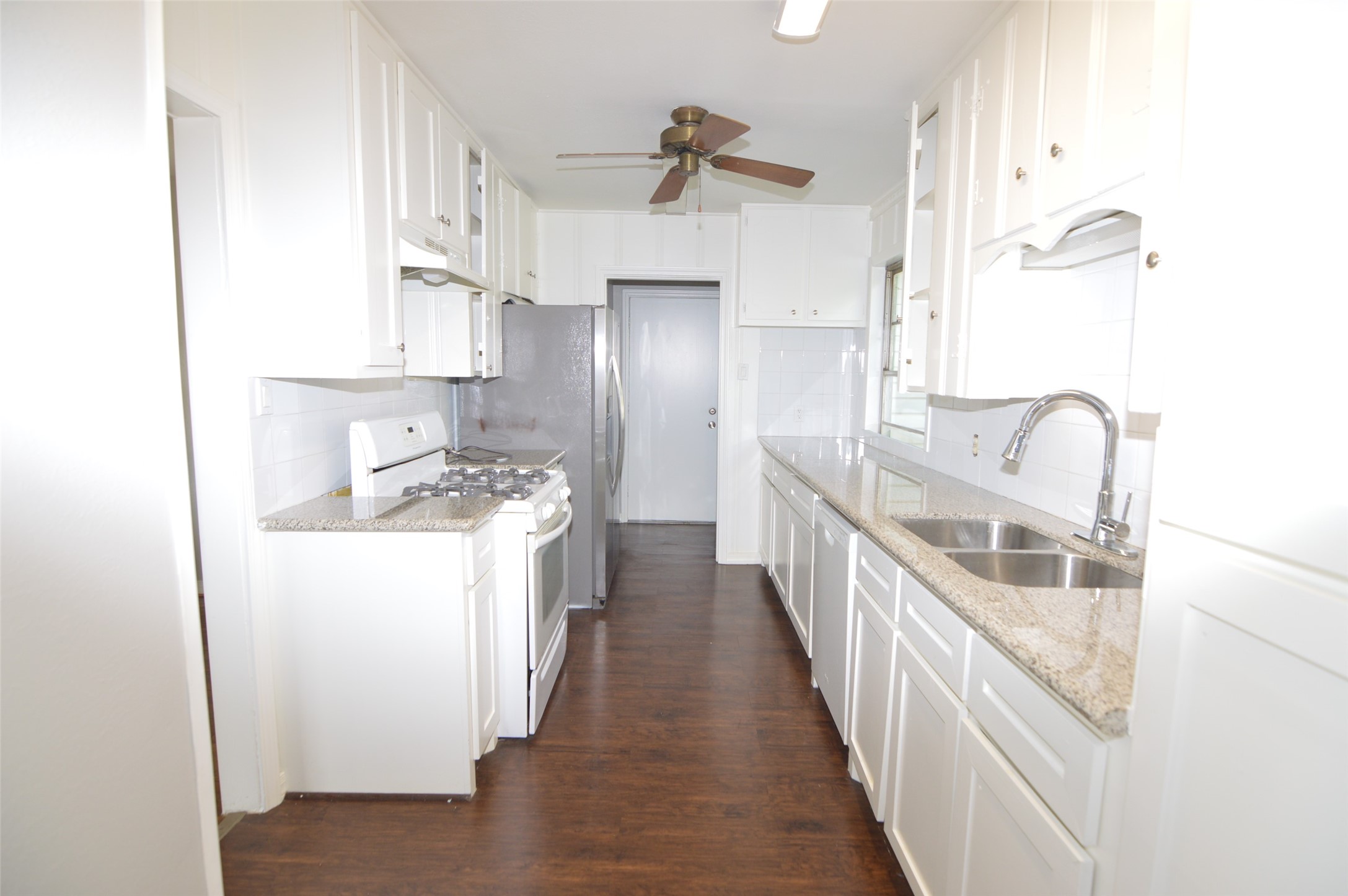 1403 Elton Street Houston, TX 77034 - Photo 7 of 21 a kitchen with kitchen island granite countertop lots of counter top space and wooden floor