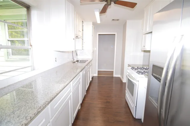 a view of a kitchen with kitchen island wooden floor and windows