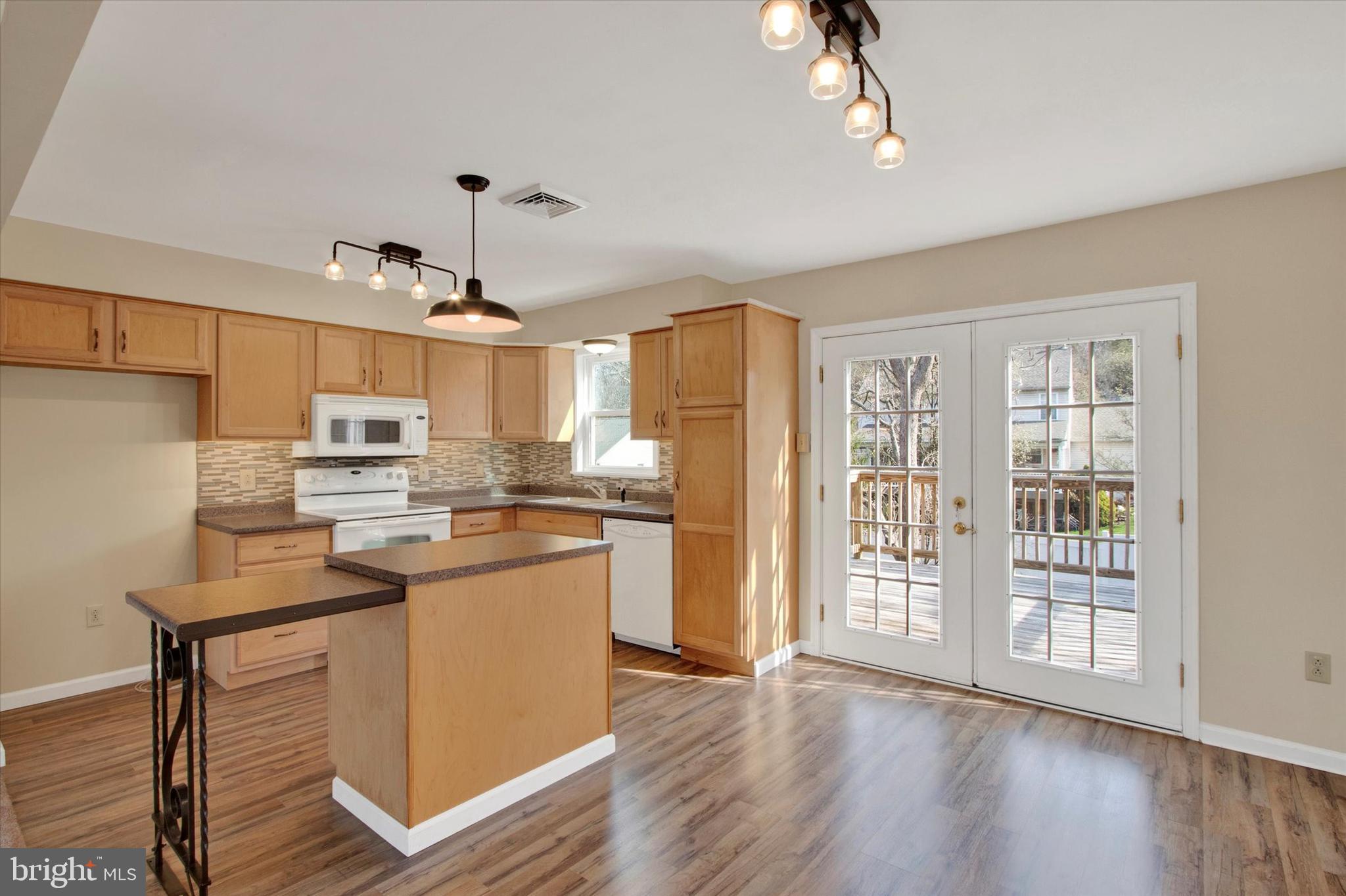 744 Tamarack Trail Reading, PA 19607 - Photo 4 of 27 a kitchen with stainless steel appliances granite countertop a refrigerator a sink dishwasher a stove and a dining table with wooden floor
