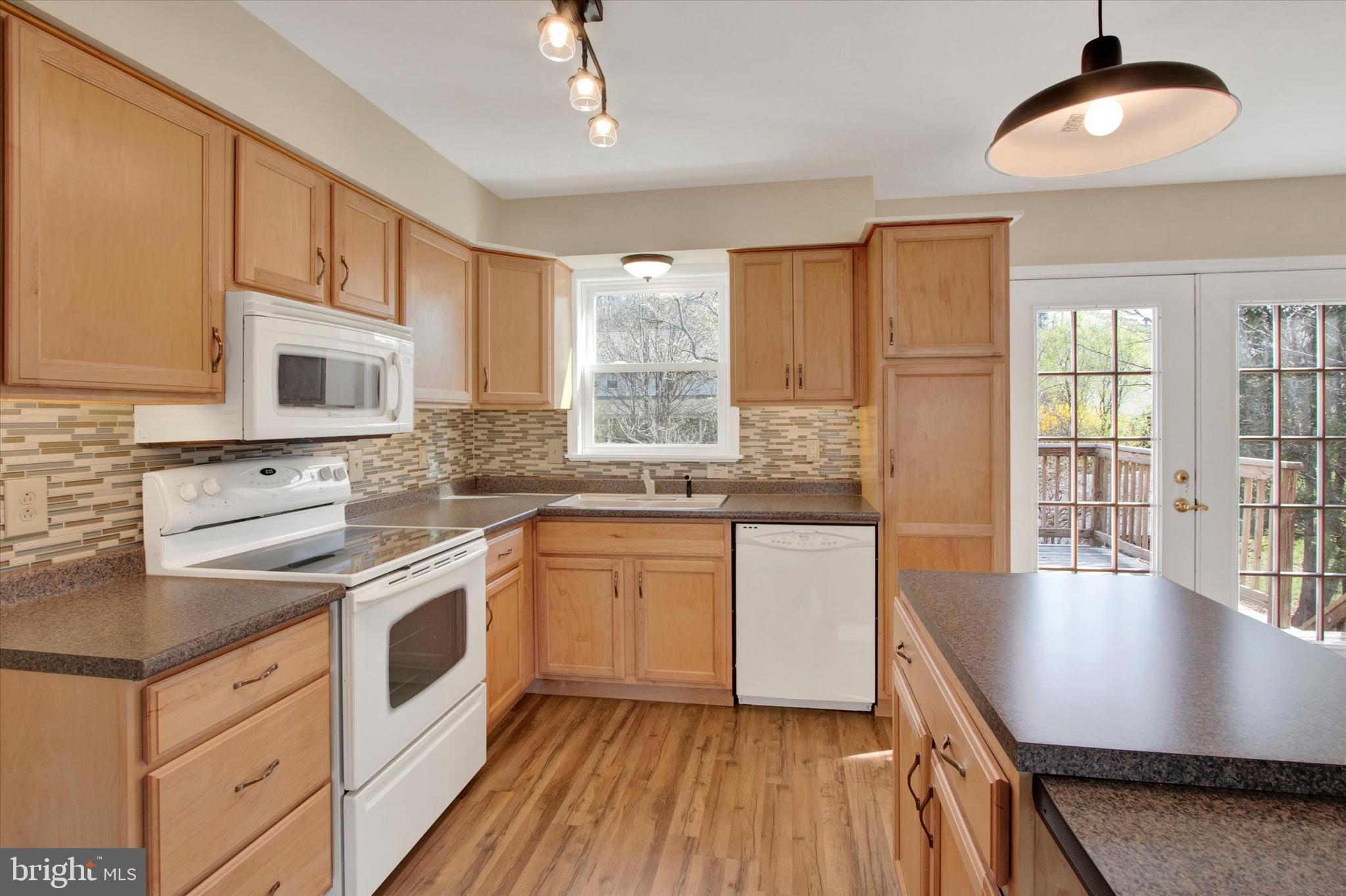 744 Tamarack Trail Reading, PA 19607 - Photo 5 of 27 a kitchen with granite countertop wooden floors and white cabinets
