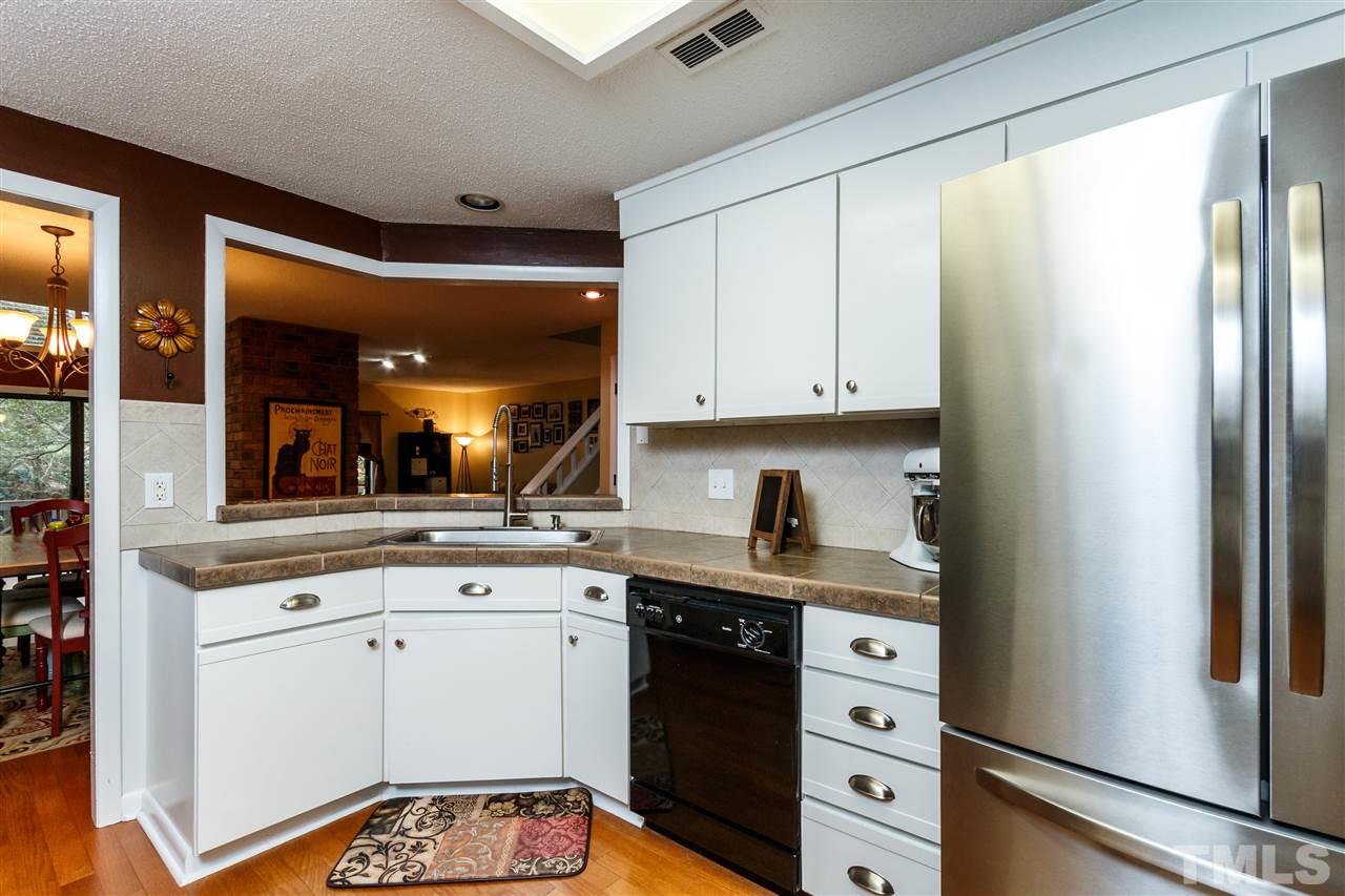 4411 Sunscape Lane Raleigh, NC 27613 - Photo 8 of 25 a kitchen with a white cabinets and white appliances