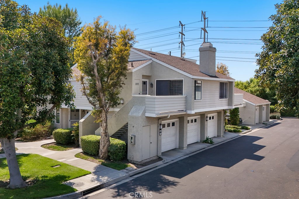 a front view of house with yard and trees in the background