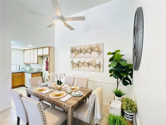a view of a dining room with furniture a potted plant and a chandelier