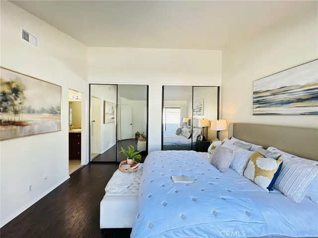 a bedroom with a large bed and painting on the wall