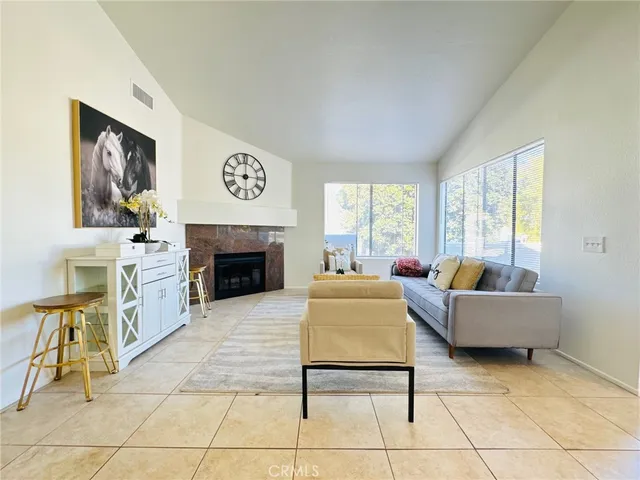 a living room with furniture a large window and a fireplace