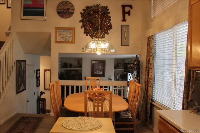 a view of a dining room with furniture and a chandelier