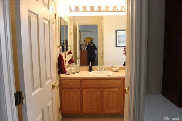 a bathroom with a sink toilet and large mirror