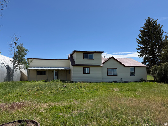 2002 Lund Road Bancroft, ID 83217 - Photo 25 of 28 Multi-level residence featuring a light-colored siding and a contrasting reddish-brown metal roof