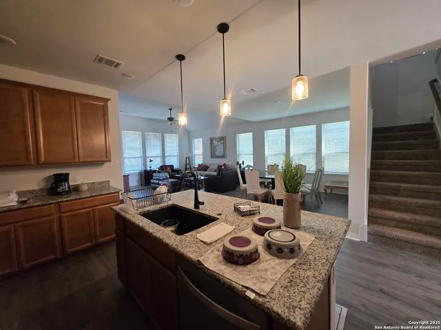 a kitchen with sink stove and wooden floor