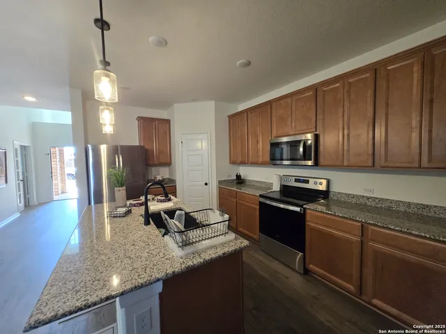 a kitchen with stainless steel appliances granite countertop a sink stove and refrigerator