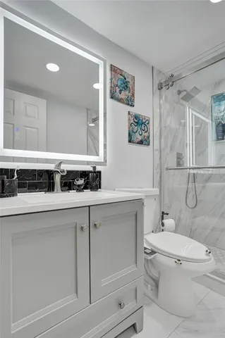 a bathroom with a sink a toilet and shower