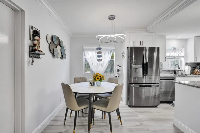 a kitchen with stainless steel appliances a refrigerator and a dining table