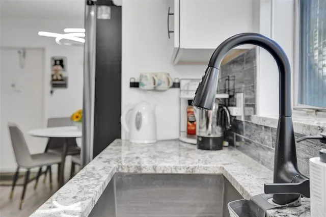 a kitchen with a faucet a dining table and chairs
