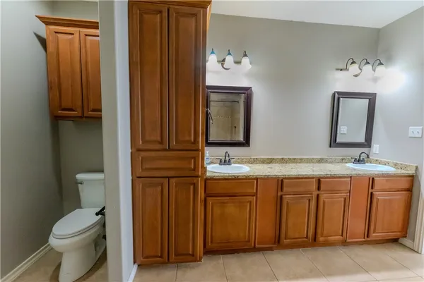 a bathroom with a toilet a sink and mirror