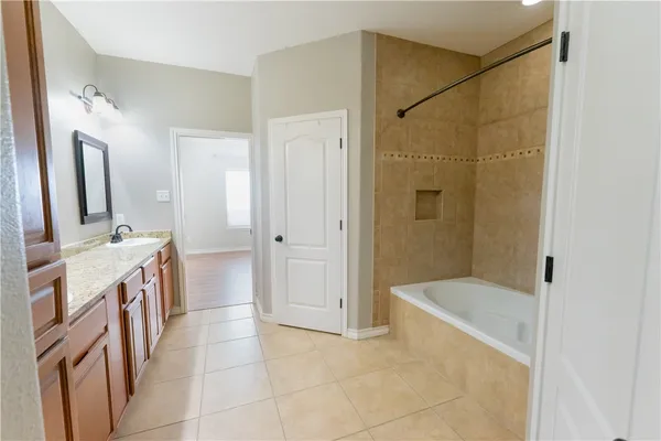 a bathroom with a tub sink and mirror