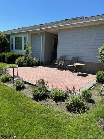 a front view of a house with a yard and outdoor seating