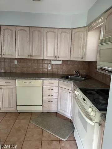 a kitchen with granite countertop white cabinets and stainless steel appliances