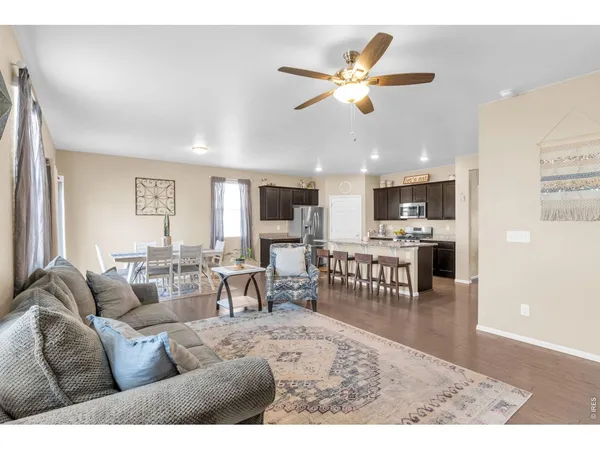a living room with furniture kitchen view and a chandelier