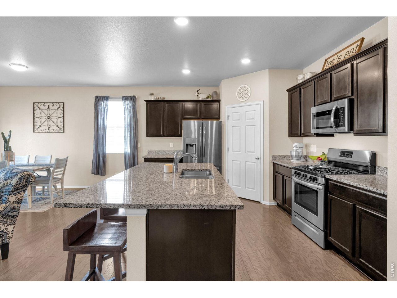 512 Buckrake Street Severance, CO 80550 - Photo 11 of 41 a kitchen with stainless steel appliances kitchen island granite countertop a stove refrigerator and cabinets