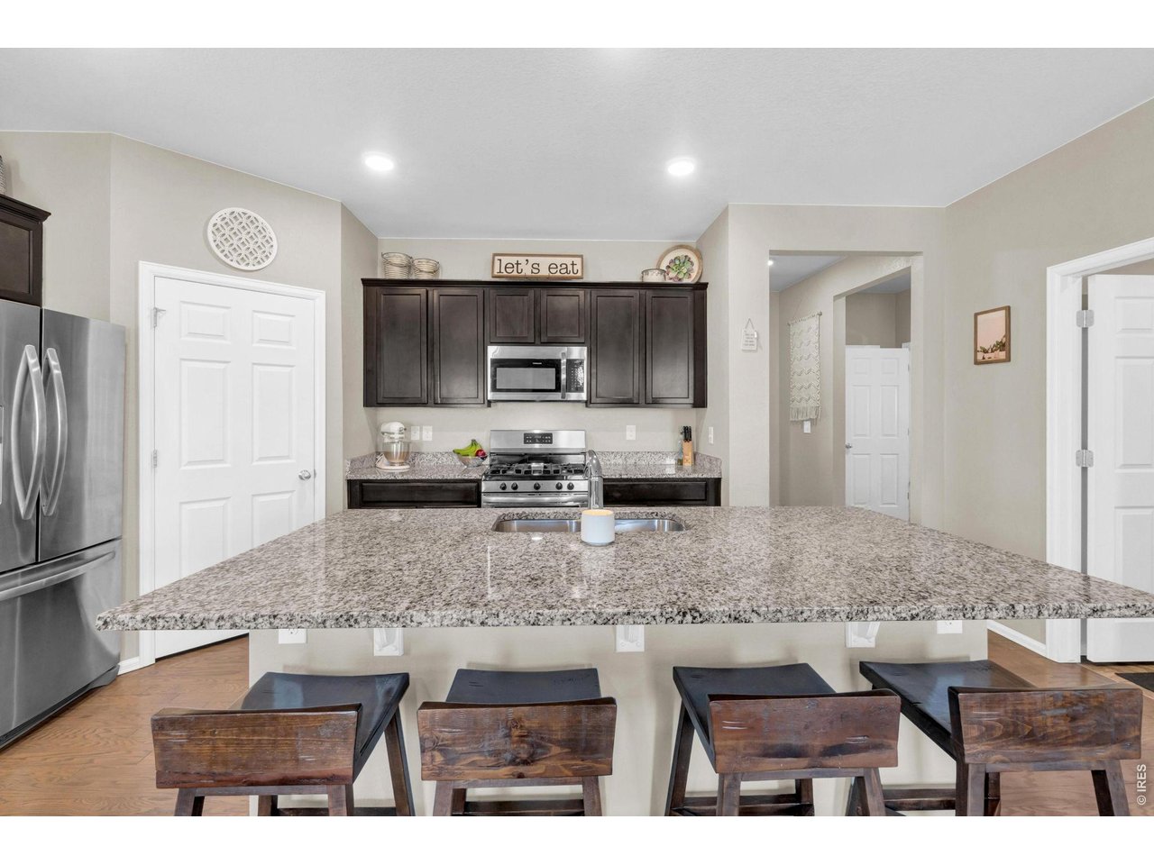 512 Buckrake Street Severance, CO 80550 - Photo 12 of 41 a kitchen with stainless steel appliances granite countertop a sink refrigerator and microwave