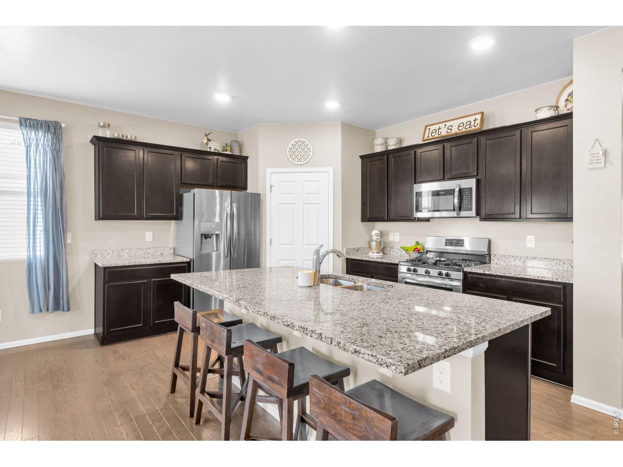 512 Buckrake Street Severance, CO 80550 - Photo 5 of 41 a kitchen with kitchen island a counter top space appliances and a refrigerator