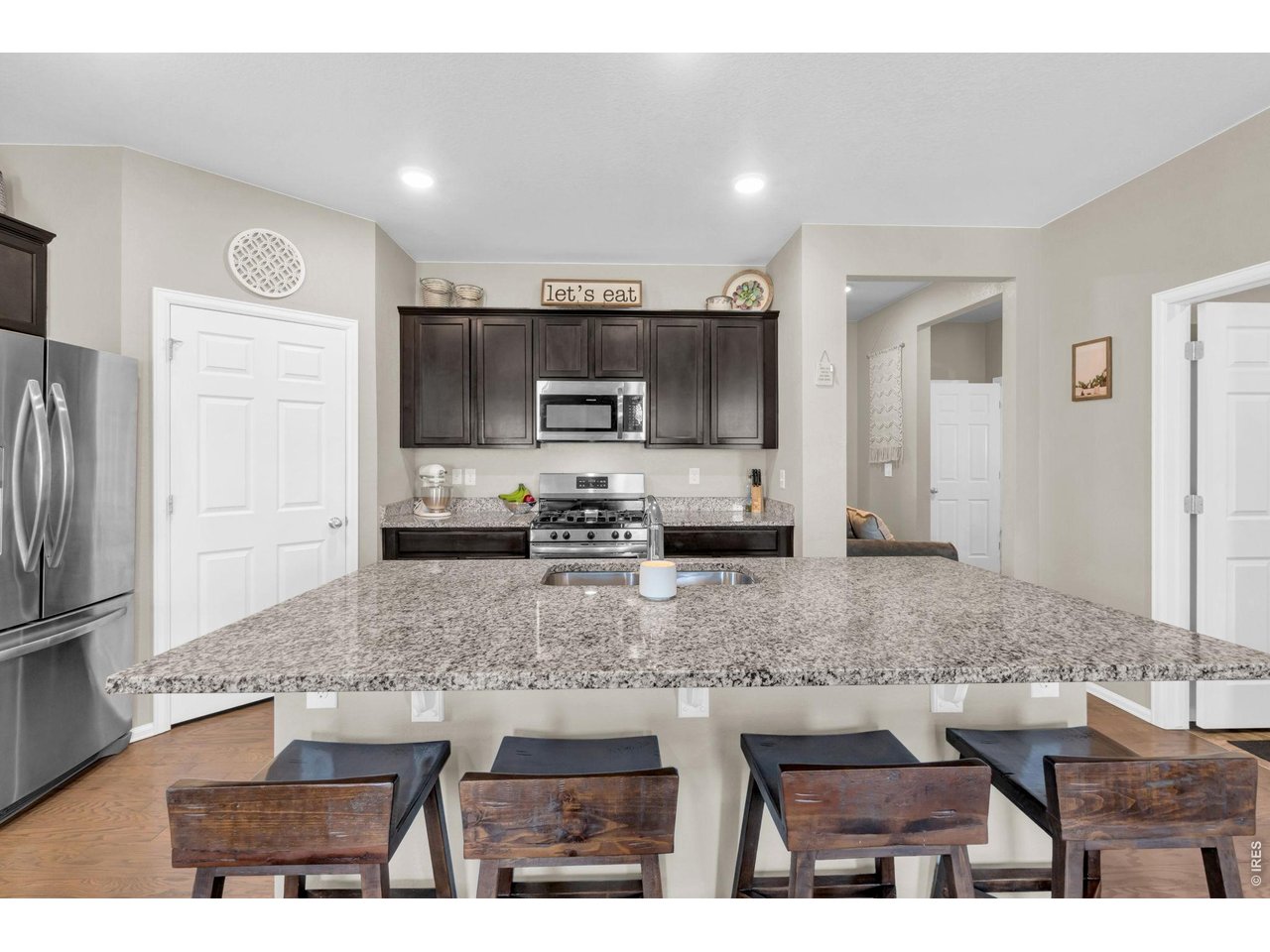 512 Buckrake Street Severance, CO 80550 - Photo 10 of 41 a kitchen with stainless steel appliances granite countertop a sink refrigerator and microwave
