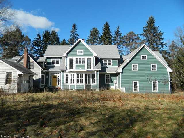a view of a big house with a big yard and large trees