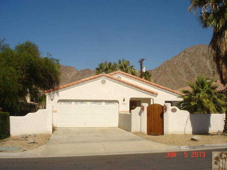 a view of white house with a yard and potted plants