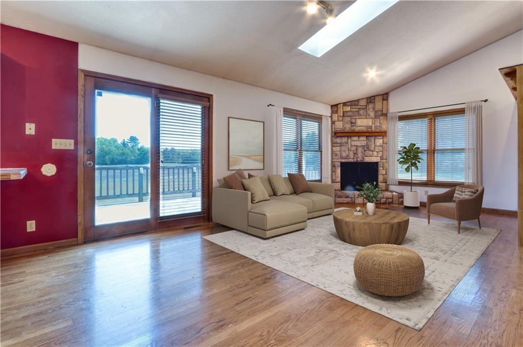 9018 North Anderson Road Hayward, WI 54843 - Photo 13 of 42 Living area with lofted ceiling, wood finished floors, a skylight, and a fireplace