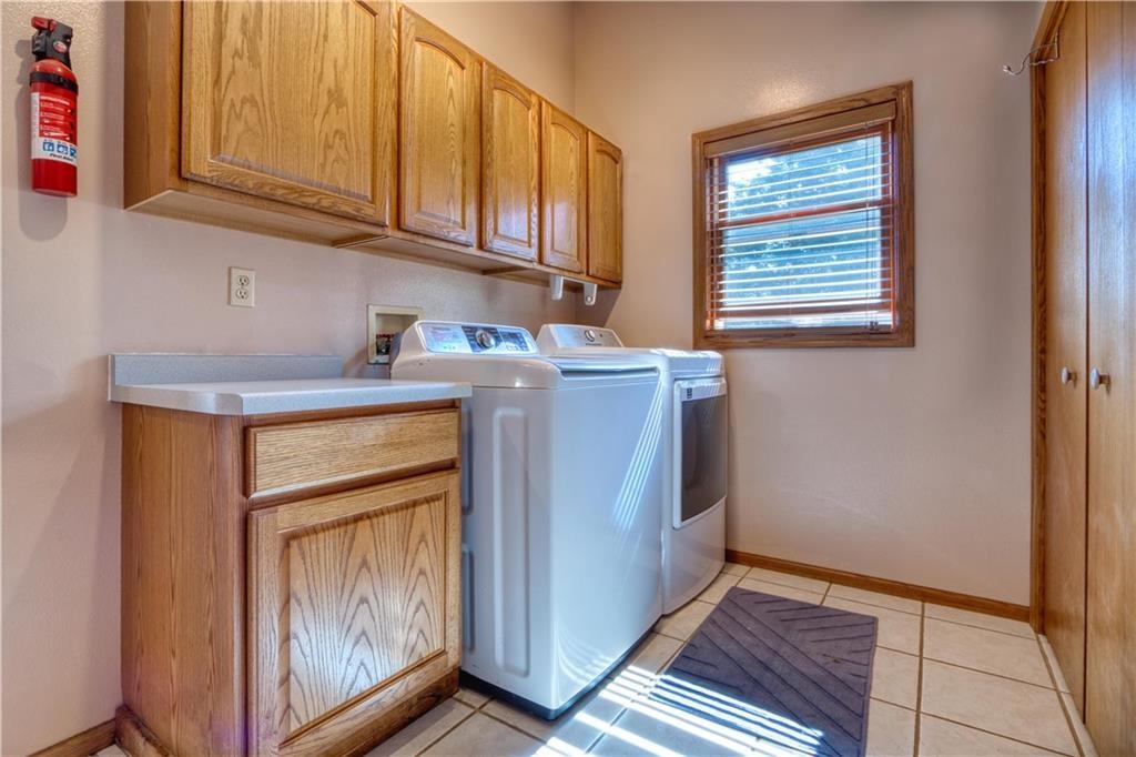 9018 North Anderson Road Hayward, WI 54843 - Photo 15 of 42 Washroom with cabinet space, washer and dryer, and light tile patterned floors