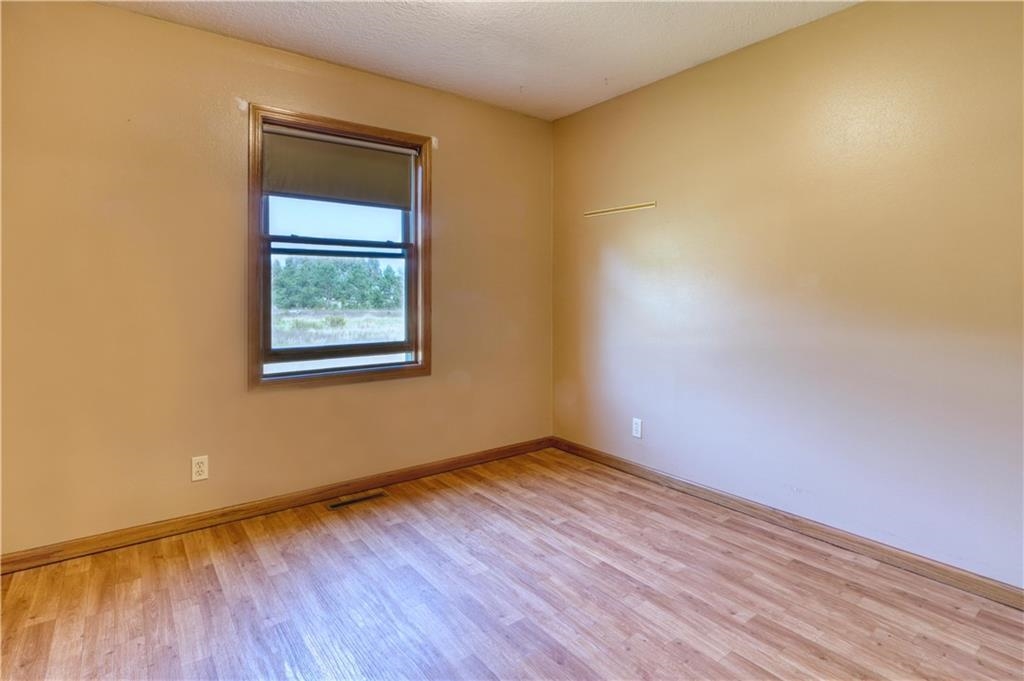 9018 North Anderson Road Hayward, WI 54843 - Photo 20 of 42 Unfurnished room with light wood finished floors and a textured ceiling