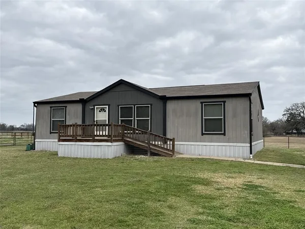 a view of a house with a yard and sitting area
