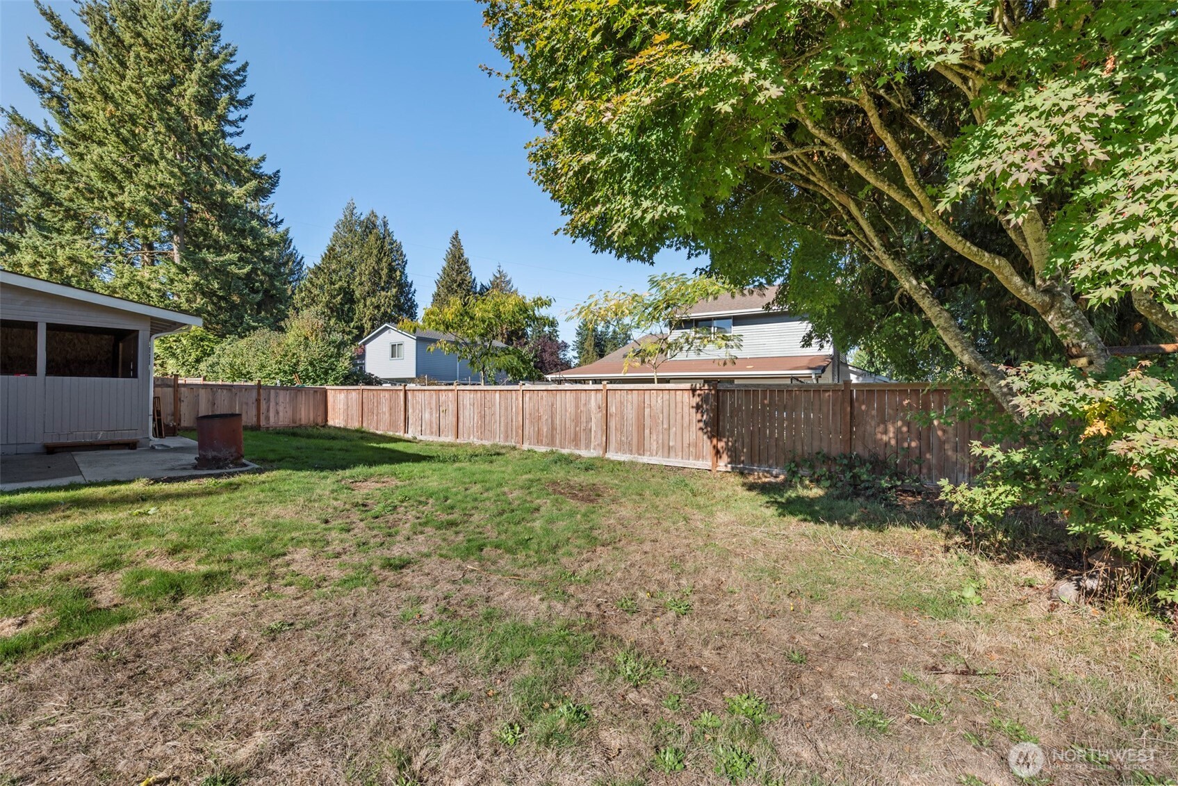5703 134th Place Southeast, Unit A Snohomish, WA 98296 - Photo 20 of 20 a view of a backyard with a trees and wooden fence