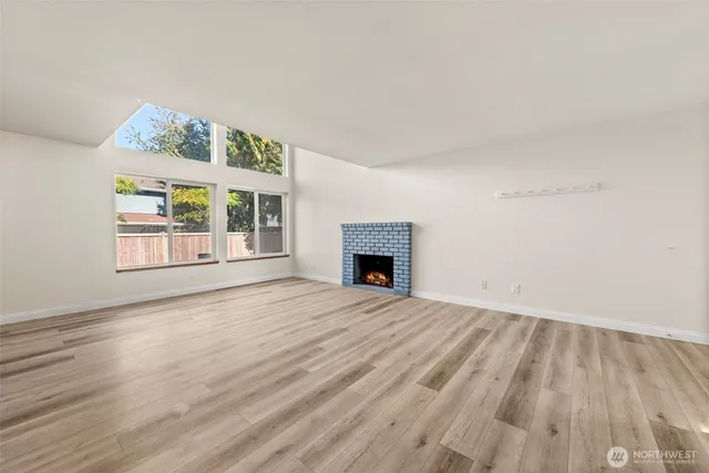 wooden floor fireplace and windows in an empty room
