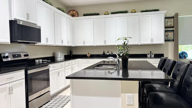 a kitchen with white cabinets sink and stainless steel appliances