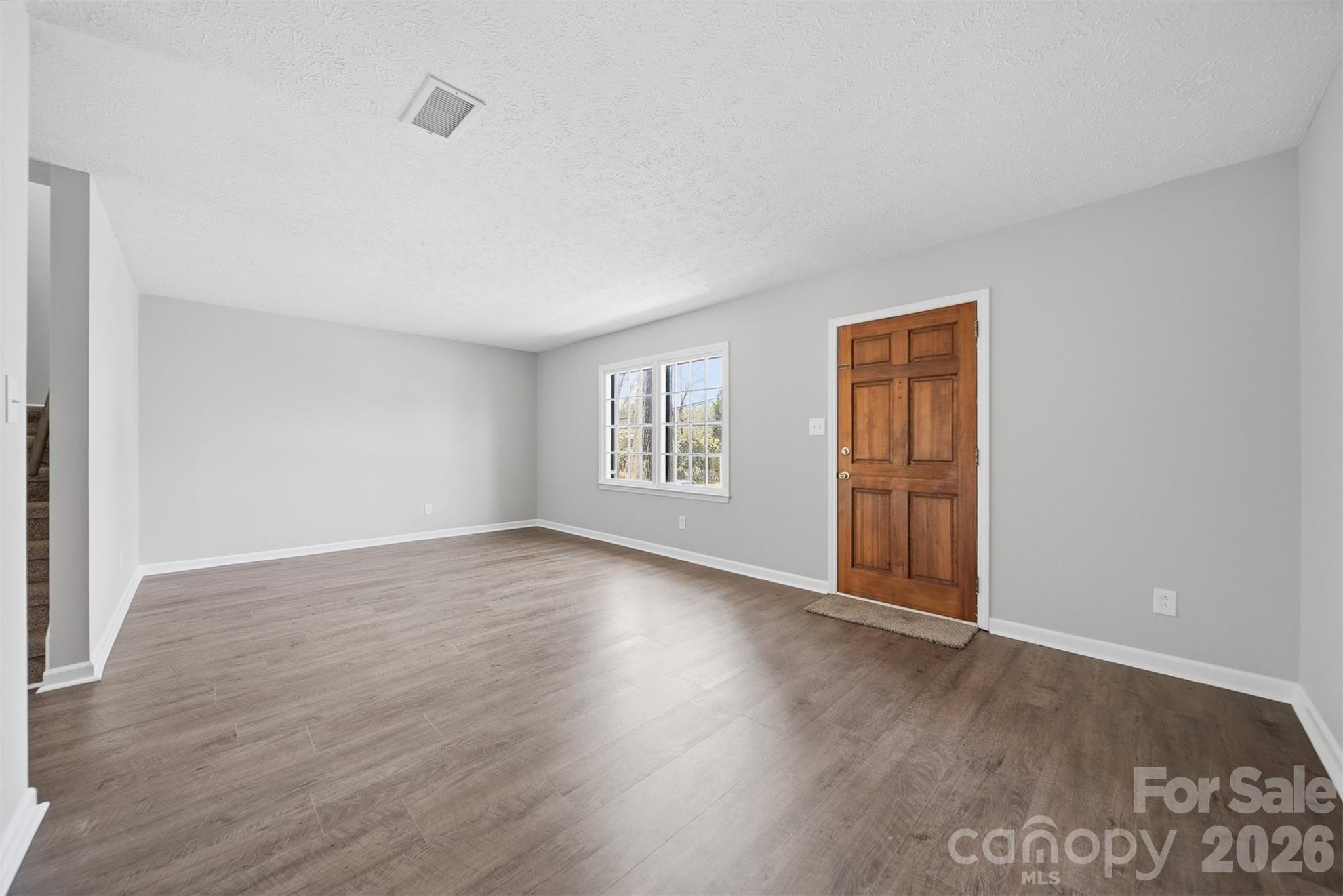 414 7th Street Northeast, Unit 2 Hickory, NC 28601 - Photo 4 of 36 a view of an empty room with wooden floor and a window