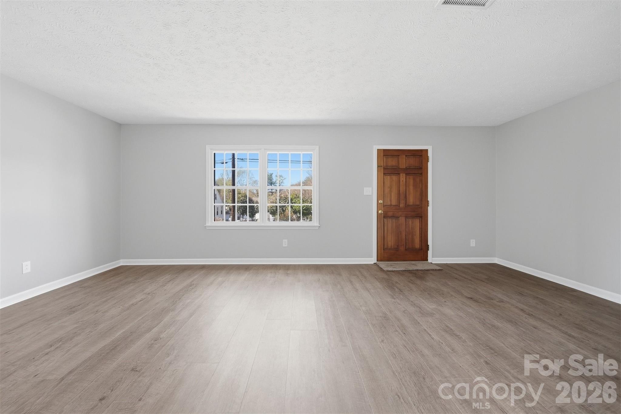 414 7th Street Northeast, Unit 2 Hickory, NC 28601 - Photo 5 of 36 a view of an empty room with window and wooden floor