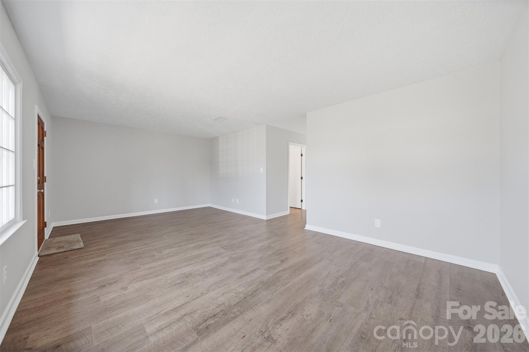414 7th Street Northeast, Unit 2 Hickory, NC 28601 - Photo 6 of 36 an empty room with wooden floor and windows