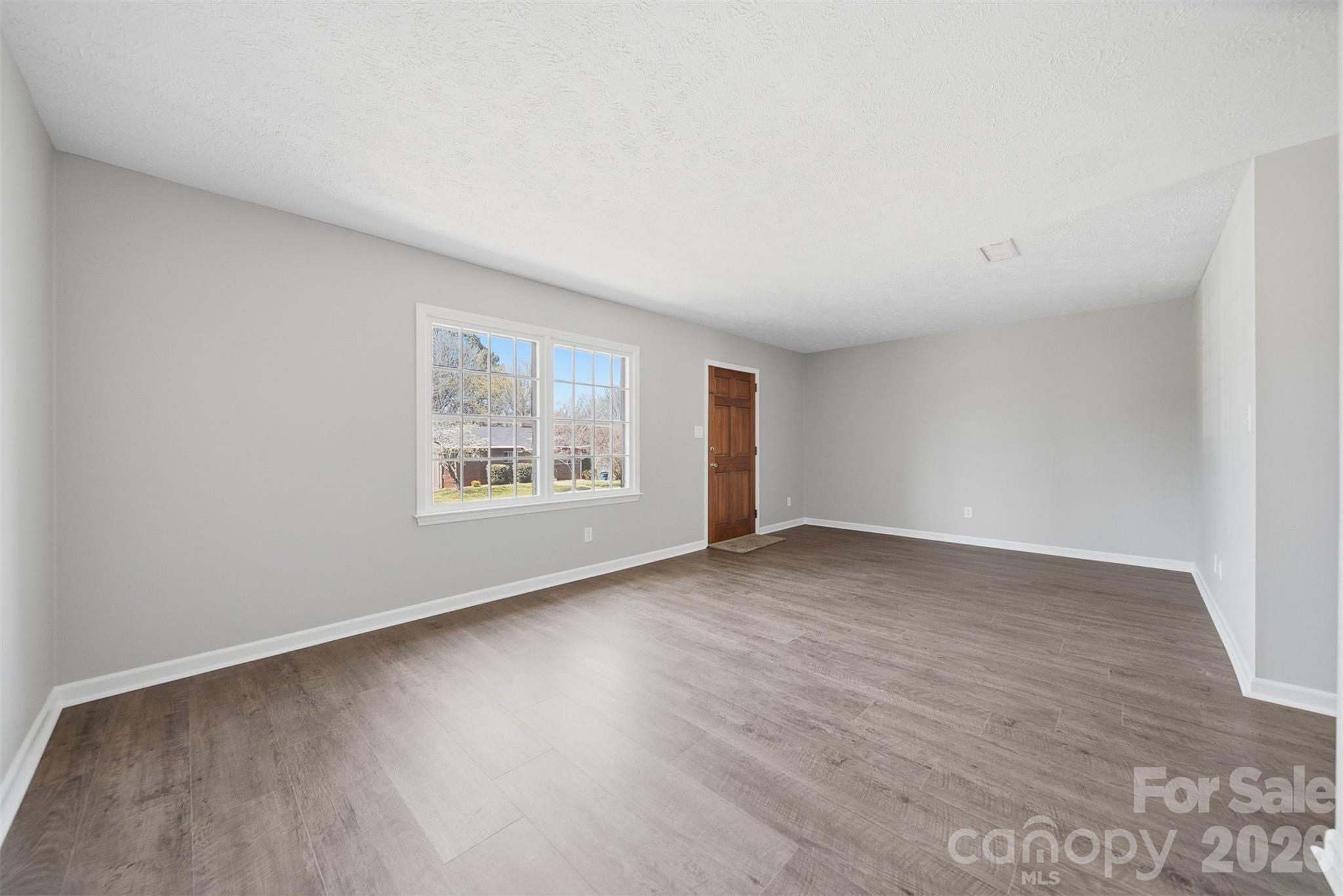 414 7th Street Northeast, Unit 2 Hickory, NC 28601 - Photo 7 of 36 a view of an empty room with wooden floor and a window