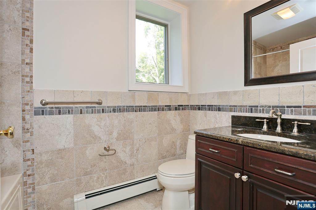 65 Ross Avenue Demarest, NJ 07627 - Photo 42 of 48 a bathroom with a granite countertop sink a toilet and a mirror