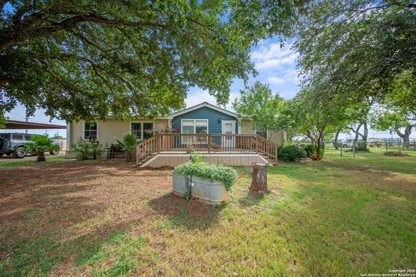 a front view of a house with a yard and green space