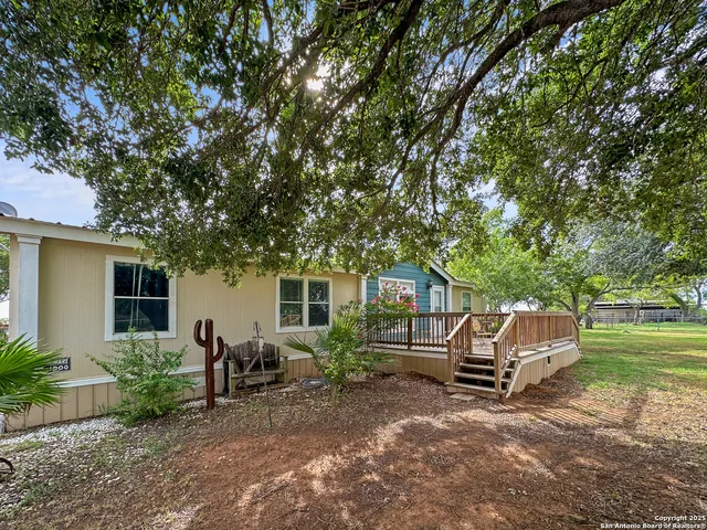 a view of backyard with wooden fence and a large tree