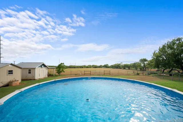 a view of a house with swimming pool and a yard