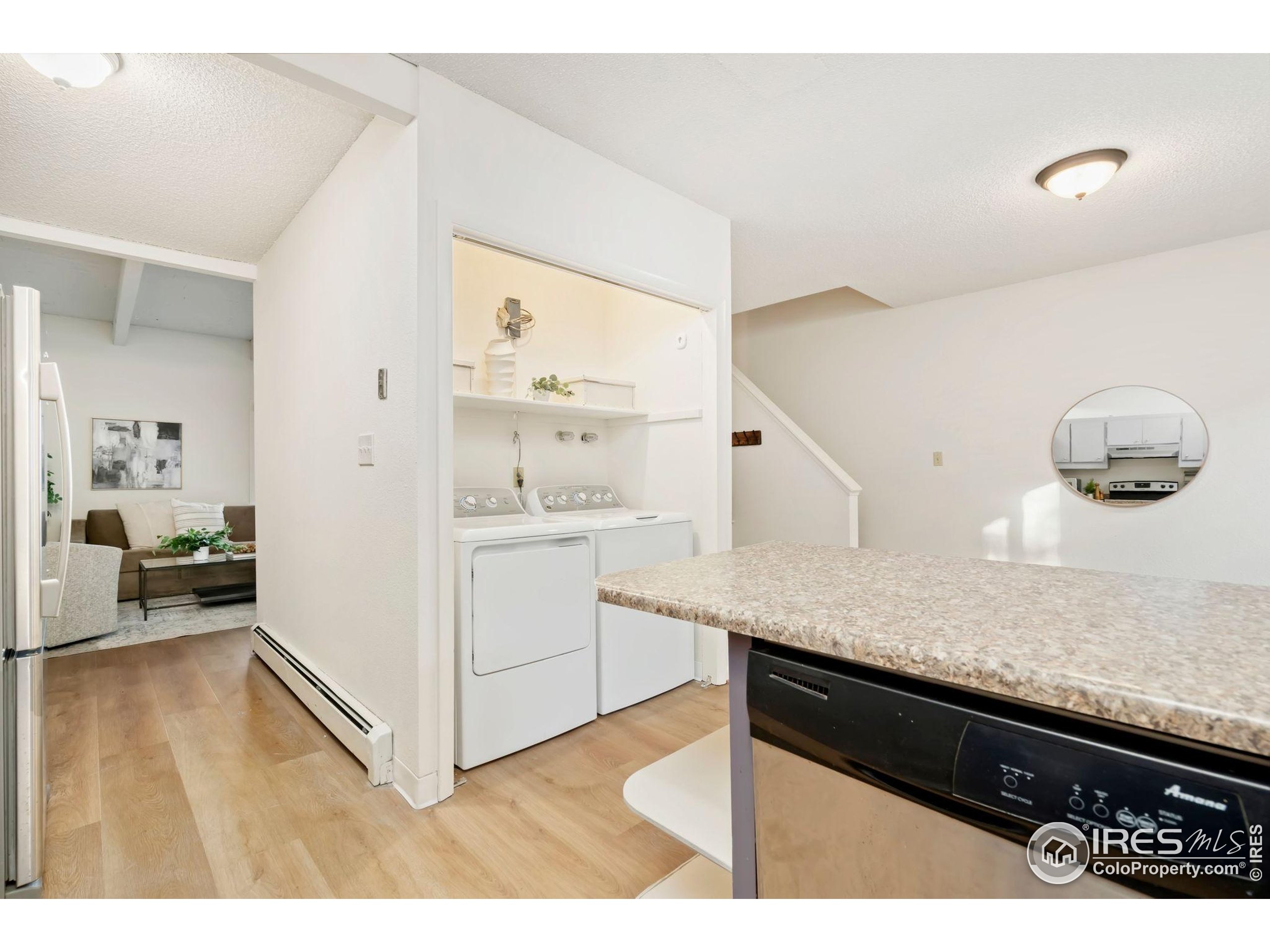 1737 Springmeadows Court, Unit A Fort Collins, CO 80525 - Photo 6 of 20 a kitchen with a sink dishwasher a stove and white cabinets with wooden floor
