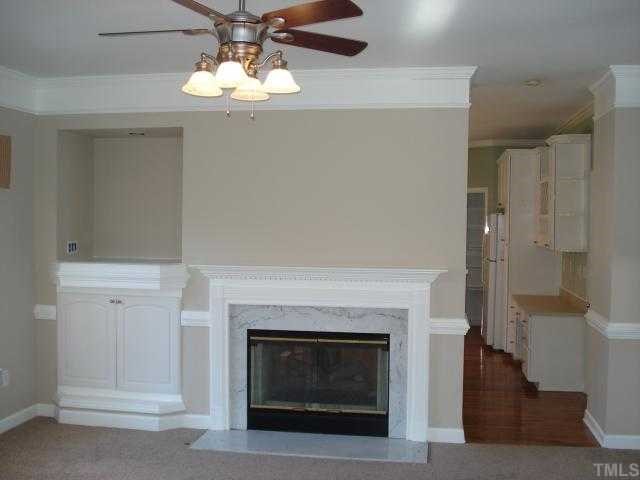 8829 Breeland Way Raleigh, NC 27613 - Photo 2 of 12 a living room with a fireplace and a chandelier