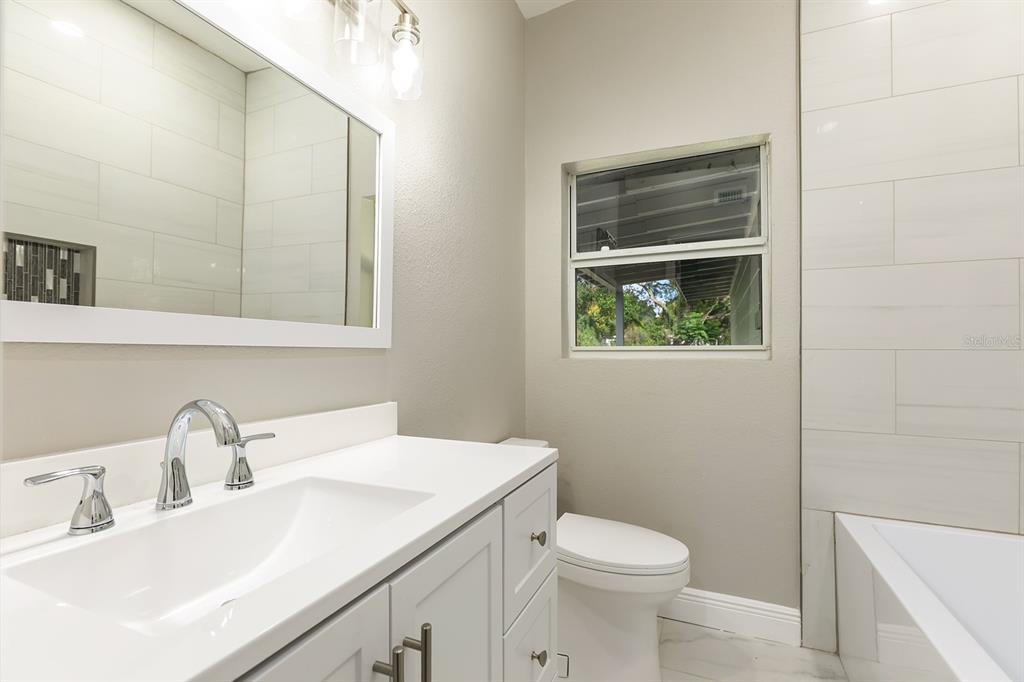 1007 San Domingo Road Orlando, FL 32808 - Photo 16 of 17 a bathroom with a sink a toilet and a mirror