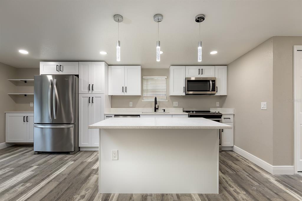 1007 San Domingo Road Orlando, FL 32808 - Photo 3 of 17 a kitchen with kitchen island a sink stainless steel appliances and cabinets