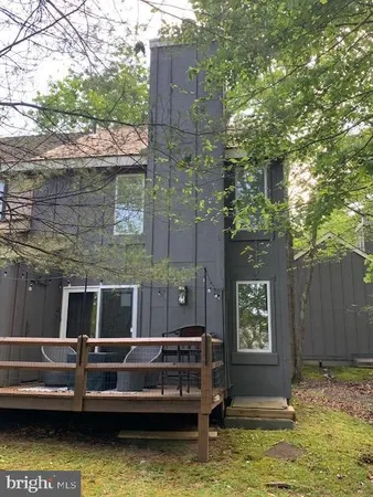 a view of swimming pool with a bench in front of house